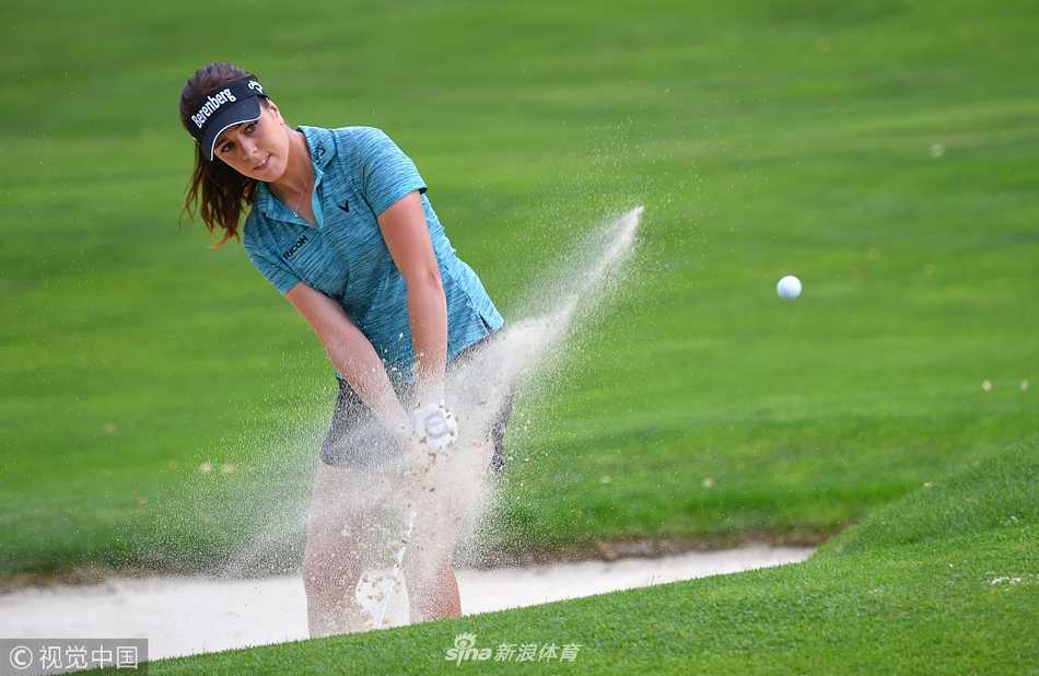 卫冕冠军在观众的注视下优雅推杆，赛场氛围紧张而热烈，凝聚了所有目光。