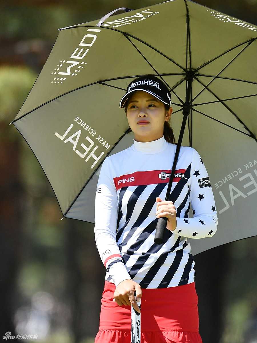 潘艳红站在球道中央，手搭凉棚远眺落点，冷静分析下一杆进攻果岭的策略与角度。