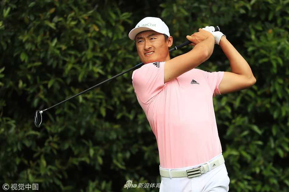 温情挥杆奥古斯塔:李昊桐与家人的大师赛温馨时刻 李昊桐站在发球台向观众挥手致意,自信从容,身后是郁郁葱葱的奥古斯塔球道