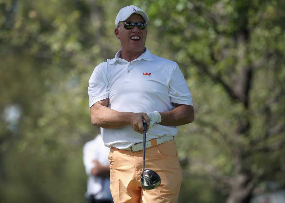 美式橄榄球明星迈克尔·埃尔维面带标志性笑容，正在高尔夫赛场边为热情的球迷签名。