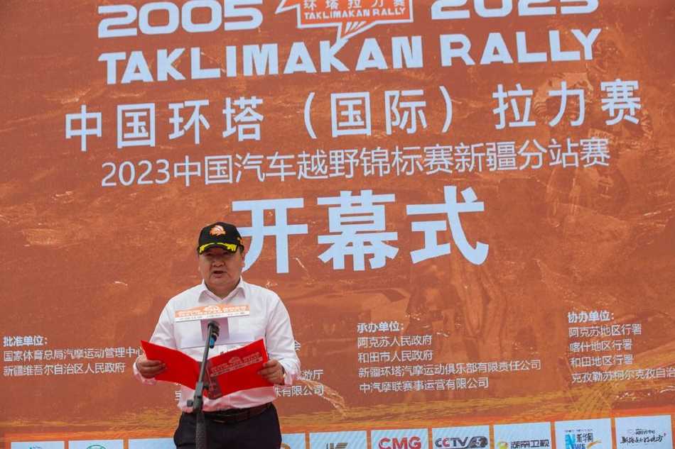 瀚海逐梦·引擎轰鸣——二〇二三年环塔拉力赛开幕盛典纪实 当地维吾尔族群众身着盛装,在赛道旁为车手们欢呼鼓舞,鲜艳的艾德莱斯绸与钢铁赛车交织出民族文化与现代竞技的和谐乐章。