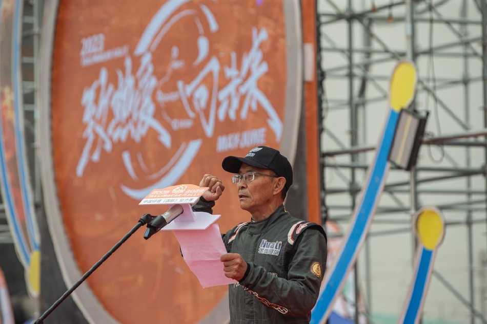 瀚海逐梦·引擎轰鸣——二〇二三年环塔拉力赛开幕盛典纪实 一辆赛车在河床赛段疾驰而过,车轮激起巨大的扇形水幕,在阳光下折射出短暂的彩虹,力量与美感瞬间定格。