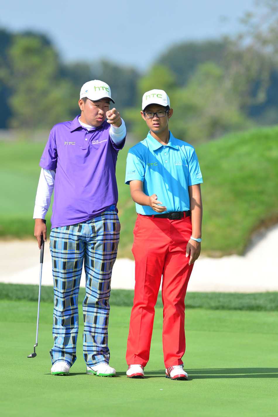 果岭边的博弈与情谊青少年高尔夫赛事中的专注时刻与团队精神 两名高尔夫球员在果岭上兴奋地击掌庆祝,脸上洋溢着成功合作后的喜悦笑容。