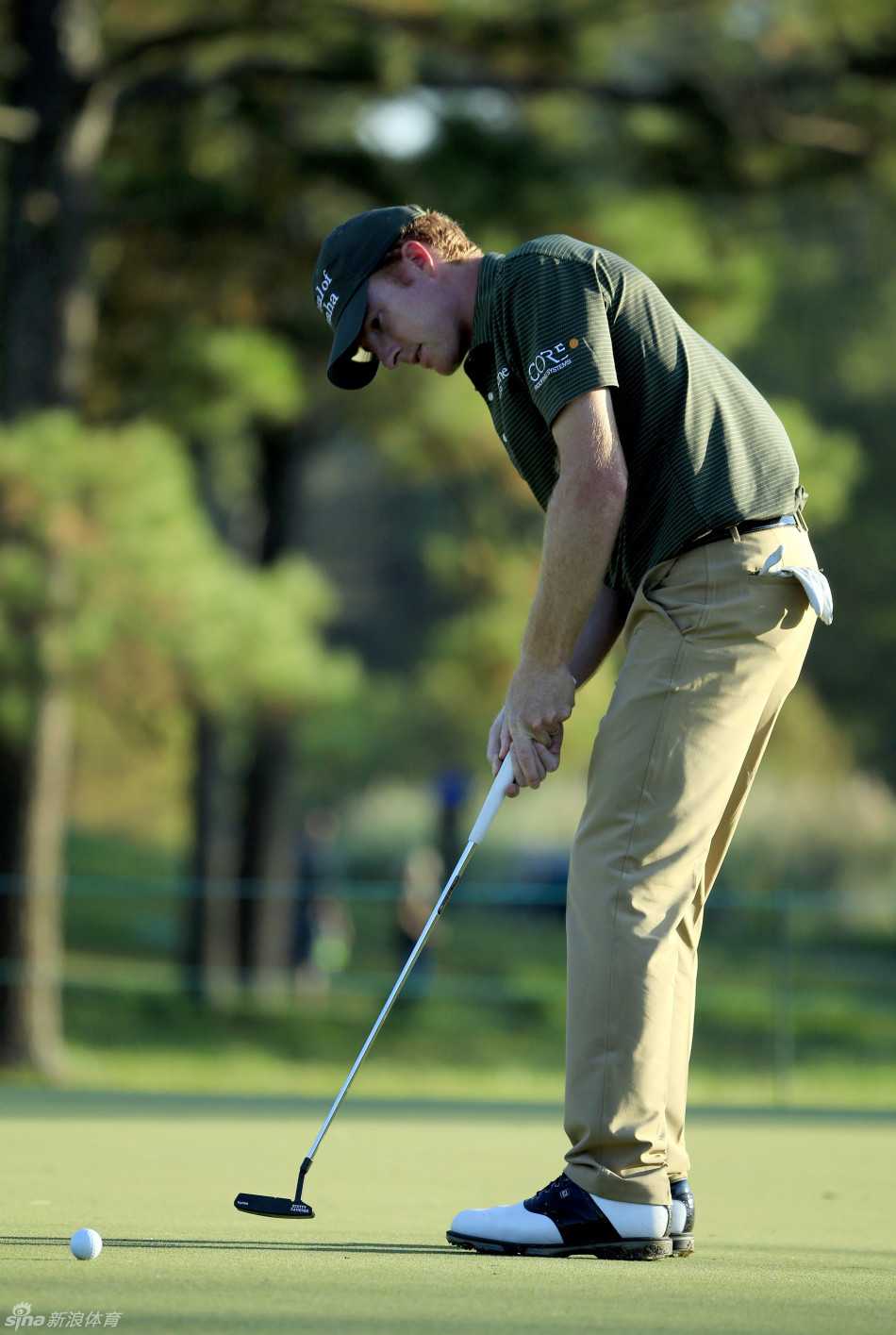 果岭风云际会 挥杆展现豪情 高尔夫球在空中飞越水障碍,倒影清晰映照在平静的湖面上