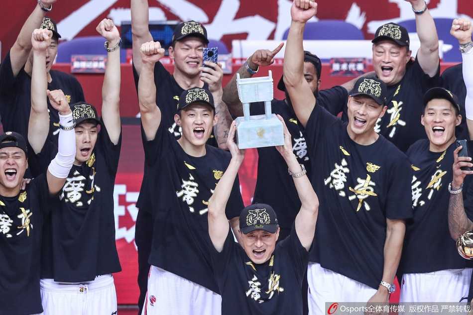 广东男篮全体成员在夺冠颁奖仪式上合影留念，金色的冠军服与手中的冠军鼎交相辉映，每个人的脸上都洋溢着胜利的喜悦与自豪，这是属于团队的辉煌瞬间。