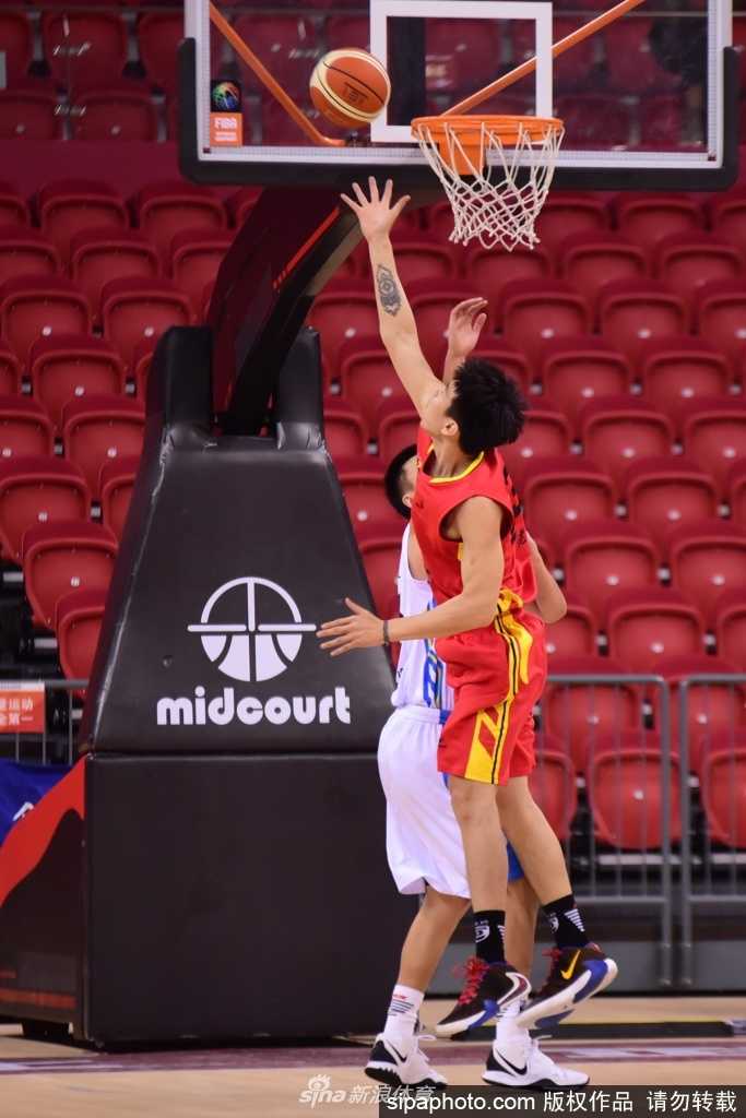 薛世伟在人群中奋力跃起，长臂舒展稳稳摘下进攻篮板，眼神中透露出不可撼动的坚定