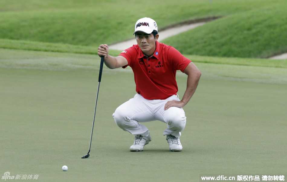 梁文冲在棕榈树背景下完成全挥杆动作，白衣在绿茵场上格外醒目