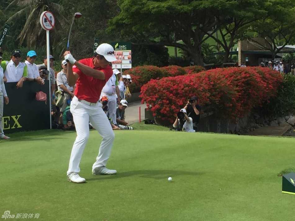 梁文冲在棕榈树环绕的球道上行走，阳光透过树叶洒在他身上