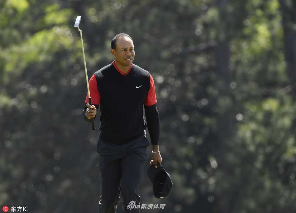 第十八洞果岭边，伍兹高举推杆告别，背影与掌声交织成经典