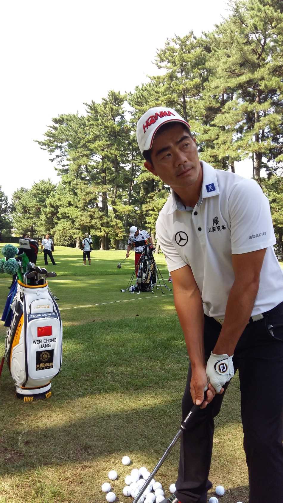 梁文冲在练习场专注地进行挥杆训练，目光坚定，为复出做最后准备