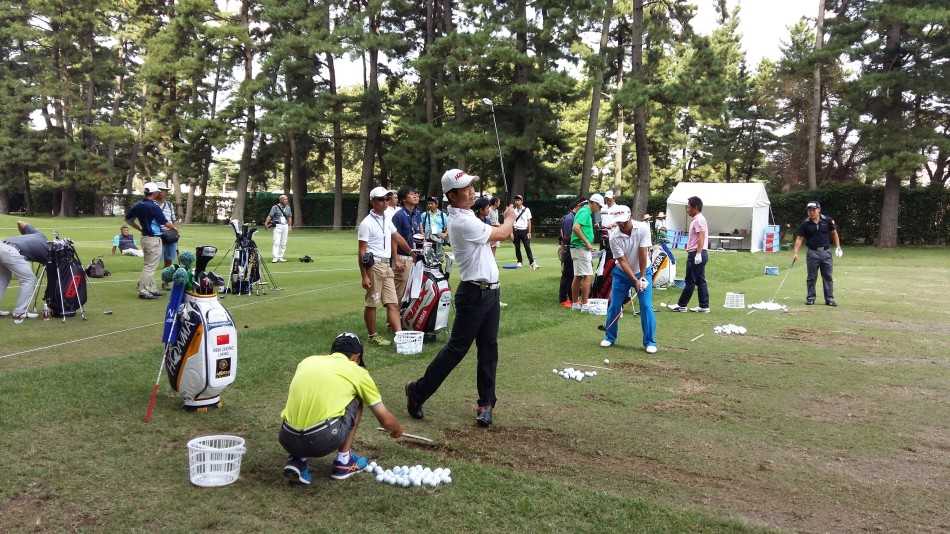 梁文冲背起球包走向下一洞，身影坚定地融入大利根乡村俱乐部的绿意之中