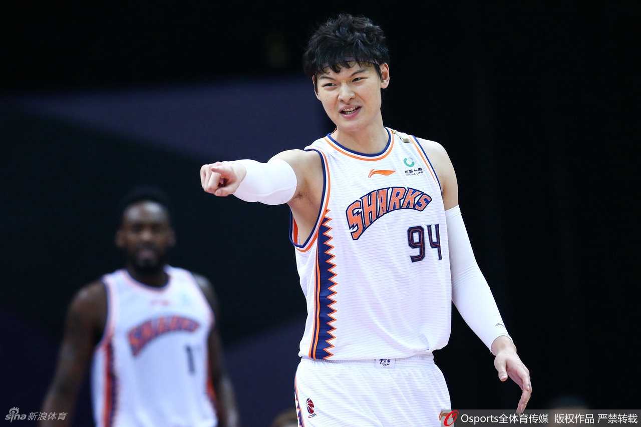 王哲林接球后顺势转身，面对福建队球员的夹防强行上篮，肌肉线条展现出极强的对抗性