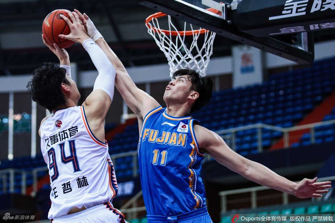 福建队陈林坚外线接球出手三分，上海队防守球员飞身扑防，球在空中划出优美弧线