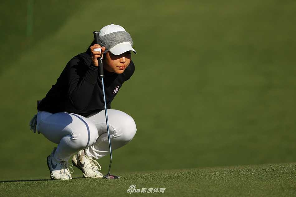 叶雷在果岭边细心观察线路，阳光洒在奥古斯塔修剪完美的草坪上