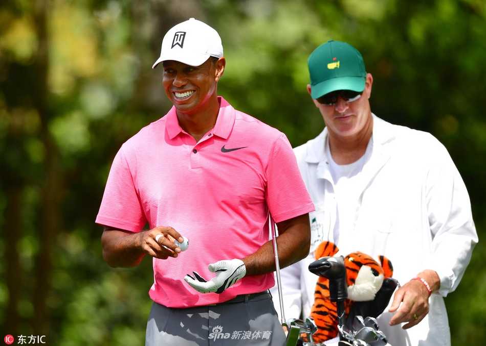 老虎伍兹手握一号木，在奥古斯塔灿烂的阳光下自信端详，球杆与绿茵构成一幅经典的备战画面。