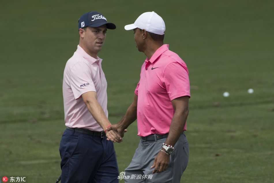 伍兹与托马斯在练习轮中并肩前行，一老一少两位巨星的身影，象征着高尔夫精神的传承与接力。