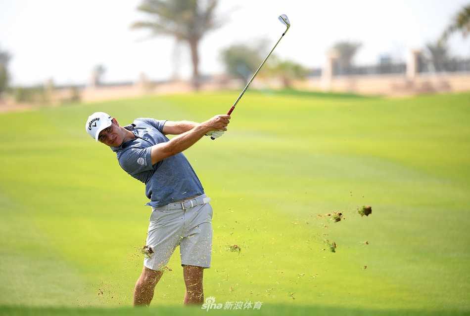 帕特里克·瑞德蹲在果岭上仔细观察坡度，全神贯注地进行推杆线路研判。