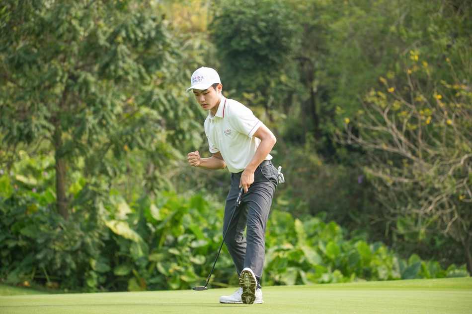 少年选手凝神屏息，在果岭边缘细致推杆，目光如炬瞄准球洞