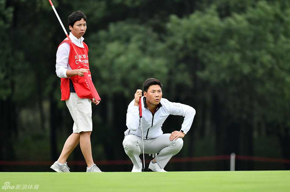 张蕙麟俯身细致观察果岭，指尖轻触草皮研判推杆线路