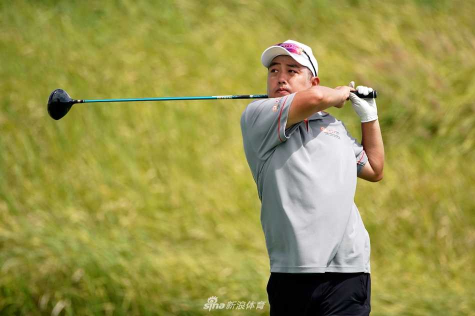 父女二人并肩走在球道上，背影融入秋日草坪的温暖色调中