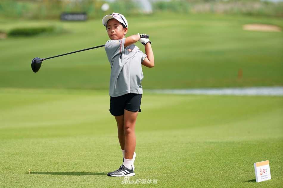 刘宇婕成功推球入洞后兴奋举手，父亲在旁露出欣慰笑容