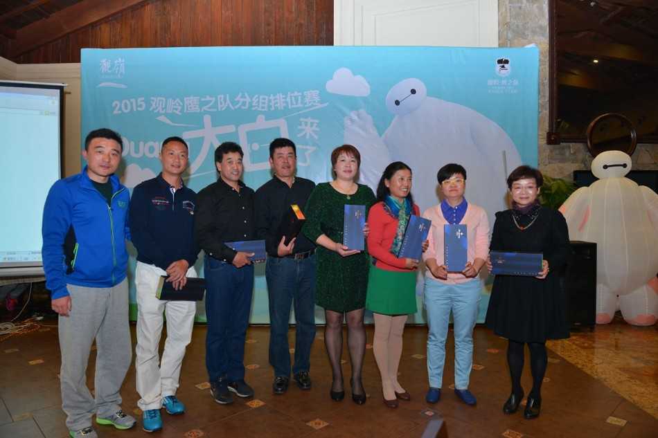 高尔夫球手在绿意盎然的观岭球场专注推杆，背景中可见‘百鸟争鸣’活动主题旗帜