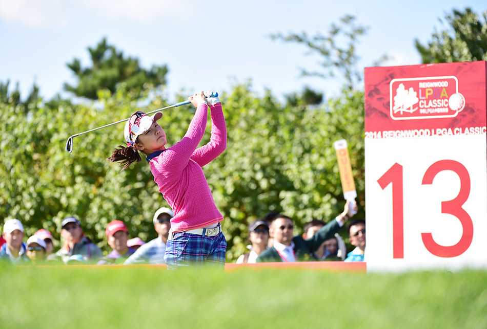 张娜伫立发球台，目光如鹰隼般追寻白色小球在蓝天下的飞行轨迹