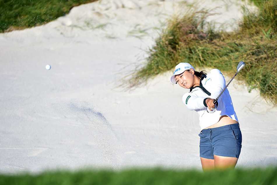 贝伦·莫佐于绿茵场边专注补妆，防晒霜瓶身反射着南国炽热的阳光