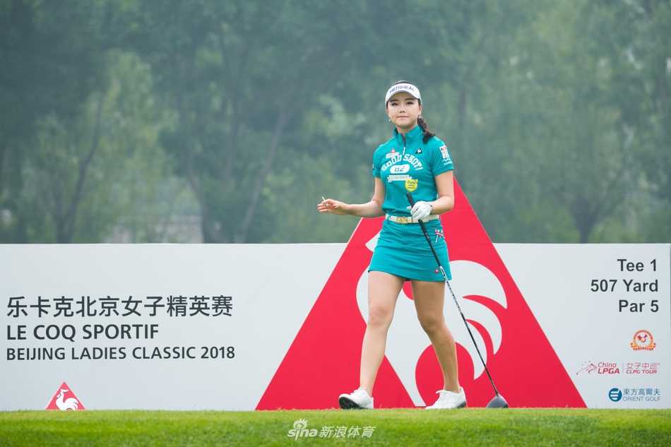 果岭上，石昱婷弯腰轻抚推杆，与球童默契商讨制胜策略