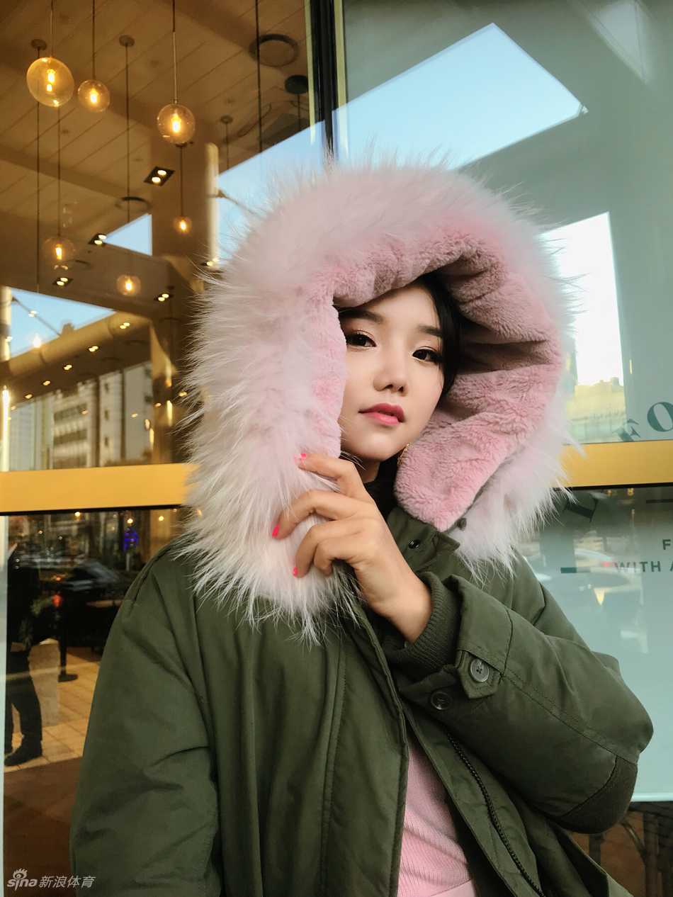 石昱婷在首尔街头露出甜美微笑，粉色系穿搭与身后温暖的灯光交织，尽显二十岁的娇俏与春日浪漫。