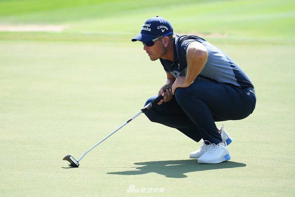 亨里克·斯滕森在沙坑中救球，强有力的挥杆溅起一片沙浪，画面充满动感与力量。