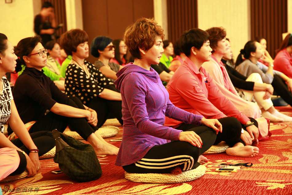 央金拉姆微笑注视沙龙参与者，她的笑容温暖包容，仿佛能融化所有紧张与焦虑