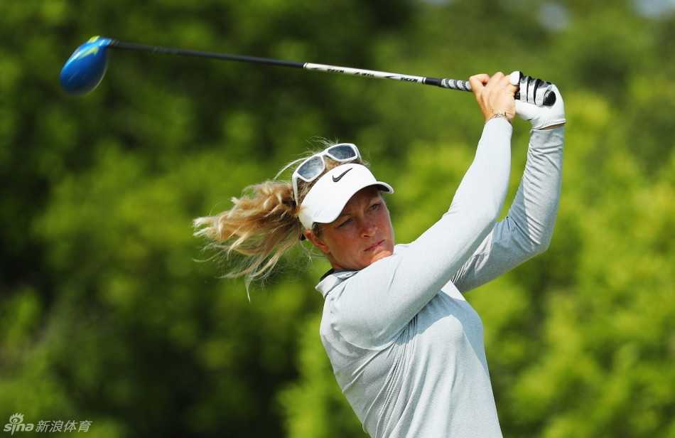 桑德拉-嘉尔在果岭边精心测算切球线路，她身体微躬，眼神锐利，全神贯注于下一次精准的击球。