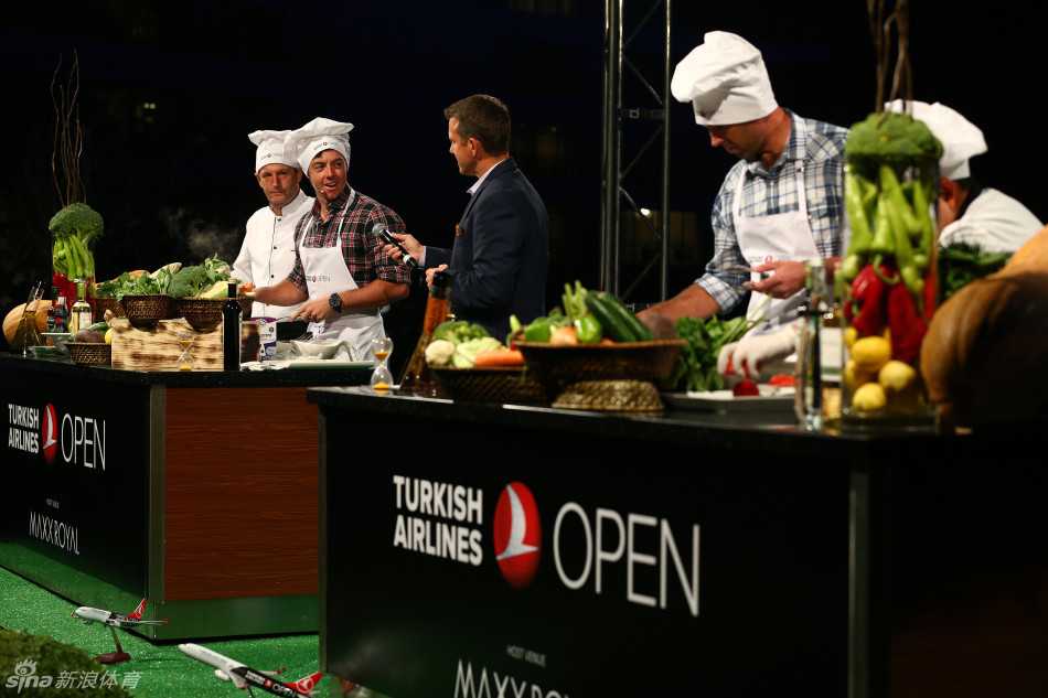 查尔·舒瓦泽尔系着围裙，与身旁的职业厨师默契交流，两人一同处理食材，舒瓦泽尔脸上洋溢着自信而灿烂的笑容。