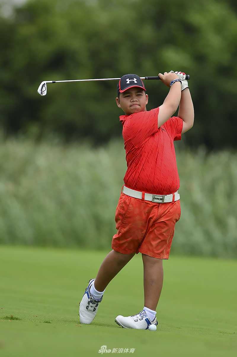 赛事创始人张连伟先生亲自为青少年球员进行指导，俯身讲解推杆技巧