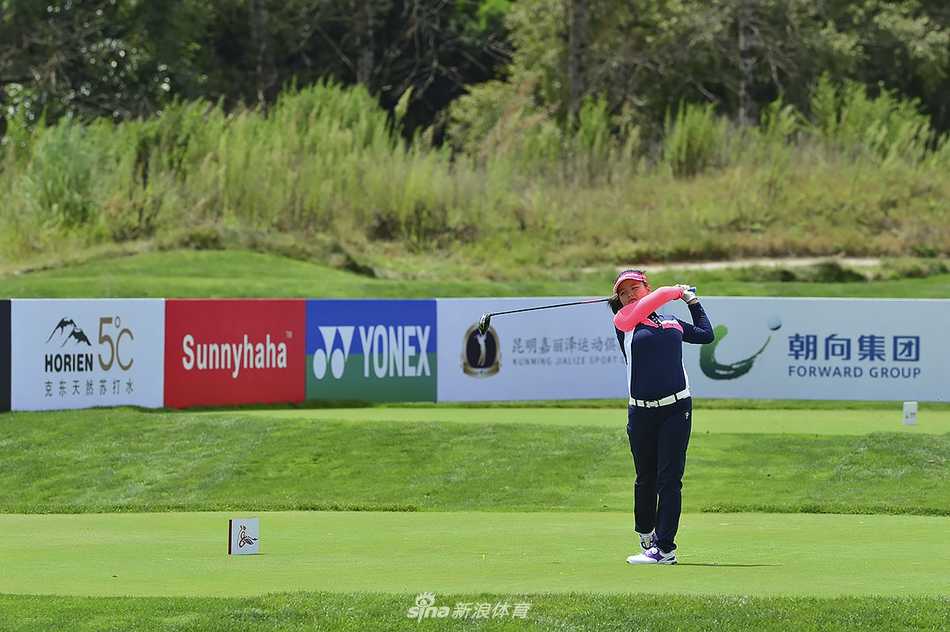 小球员在绿草如茵的球道上步行，与家人同行背影温馨，尽享高尔夫运动的乐趣