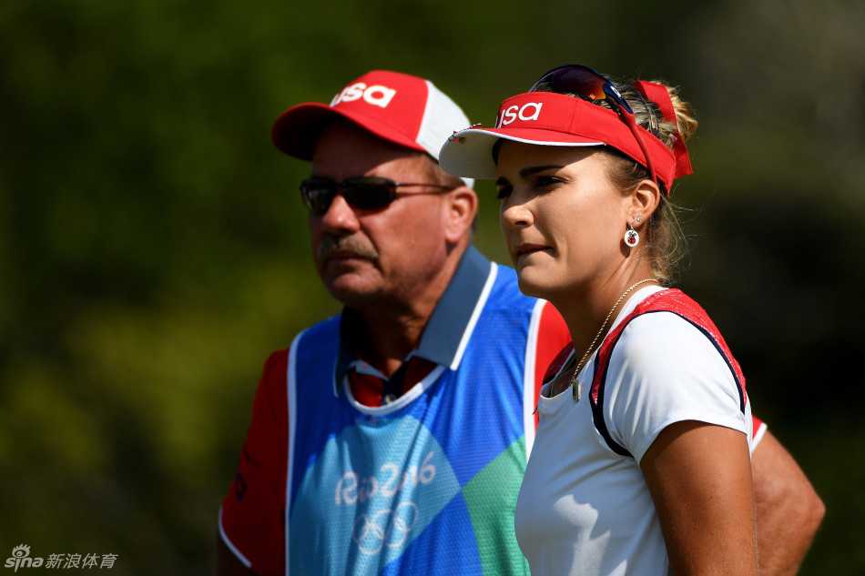 父亲陪伴着汤普森进行赛前热身，他专注地为女儿递上毛巾，平凡动作中蕴藏着深沉的父爱。