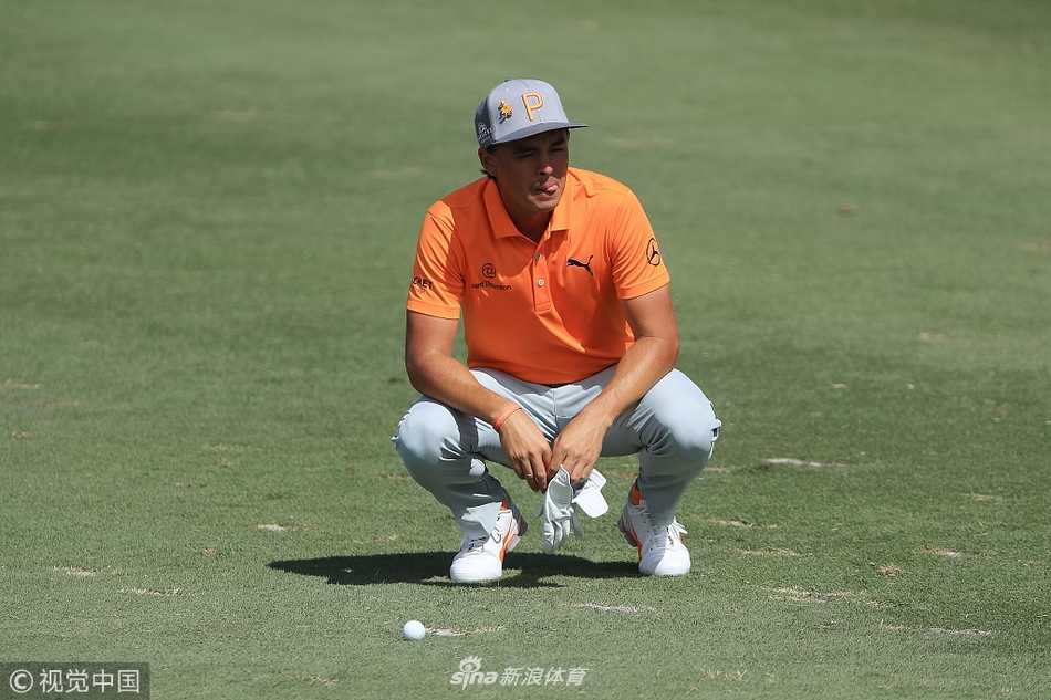 里奇·福勒在四号洞果岭边仔细研判推杆线路，他蹲下身，表情专注，试图解读果岭的每一丝起伏。