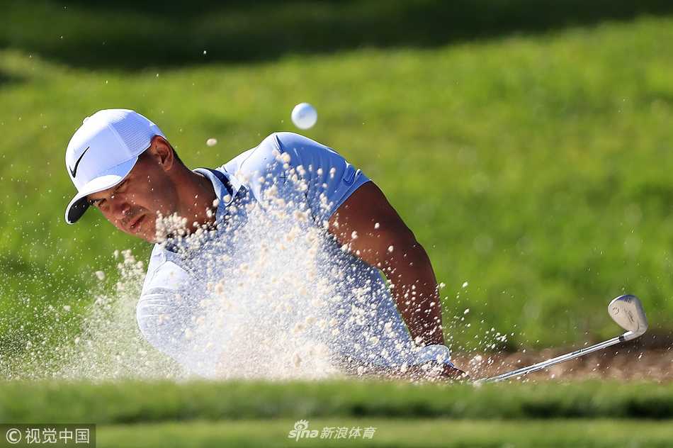 赛尔希奥·加西亚在果岭上弯腰查看推杆线路，手指指向地面，与球童进行着关键的策略交流。