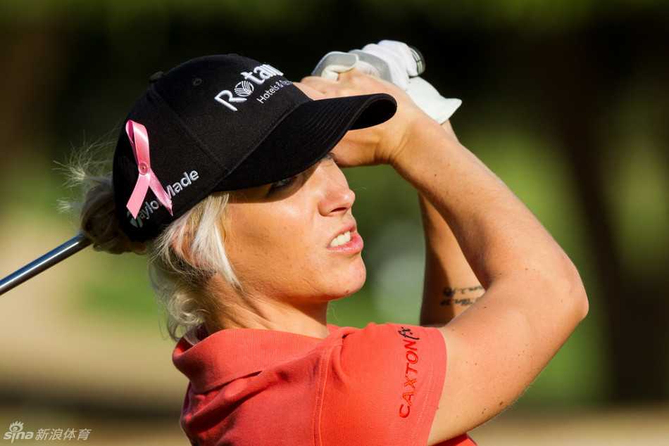 法国选手雅德·谢菲尔在迪拜的阳光下全神贯注地挥杆，粉红丝带在她帽子上轻轻飘扬，成为竞技场上一个温暖的焦点。