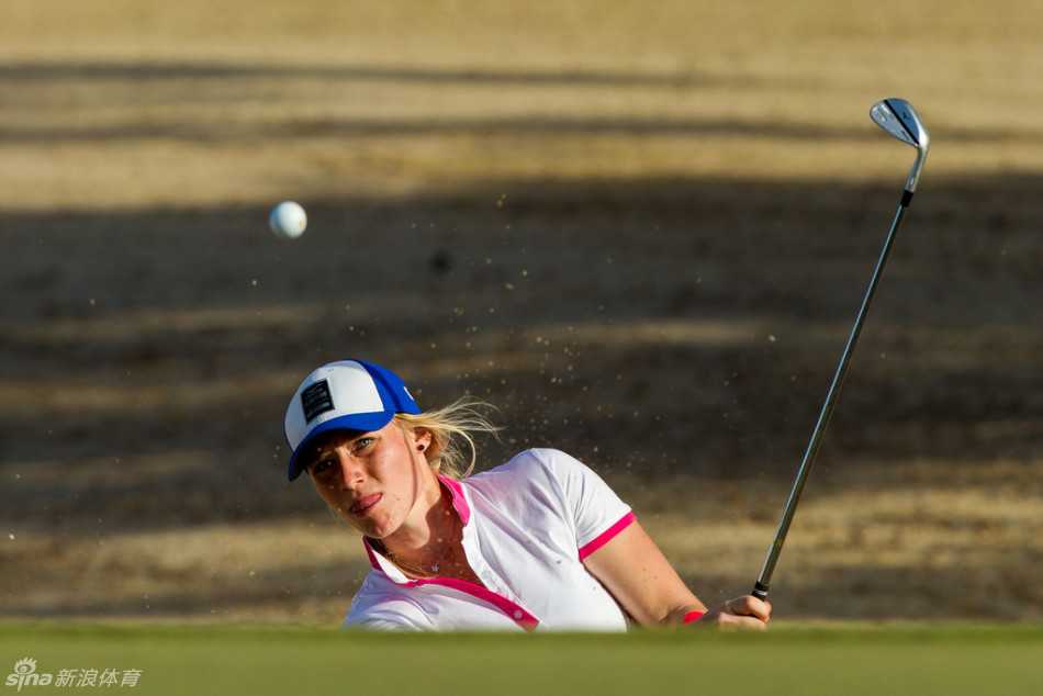 雅德·谢菲尔在球道上优雅完成一次击球，粉红丝带在她胸前清晰可见，展现了力量与柔美的结合。