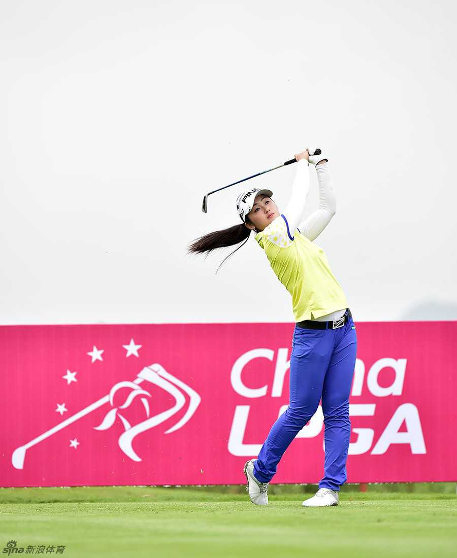 泰国选手彭娜帕在果岭边细心观察推杆线路，阳光洒在她的帽檐上