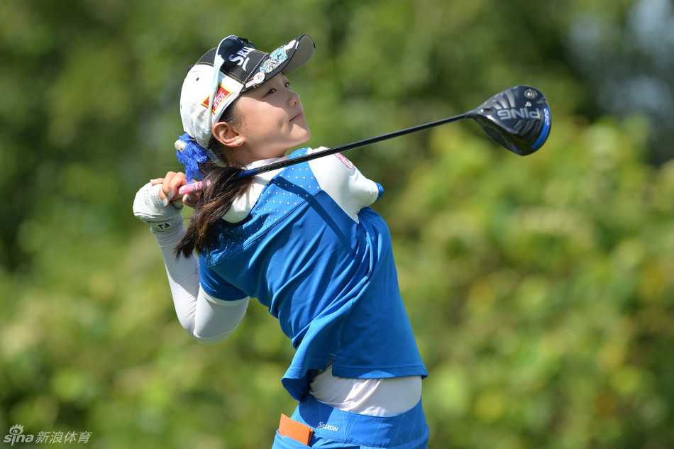 石昱婷全神贯注，优雅挥杆开球，白色球帽下目光如炬直视前方。