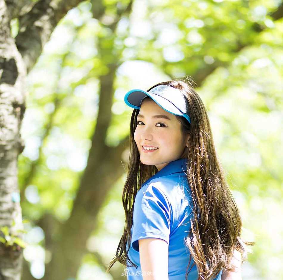 高尔夫女孩自信地站在发球台，手持球杆望向远方，身后是开阔而充满挑战的球场。