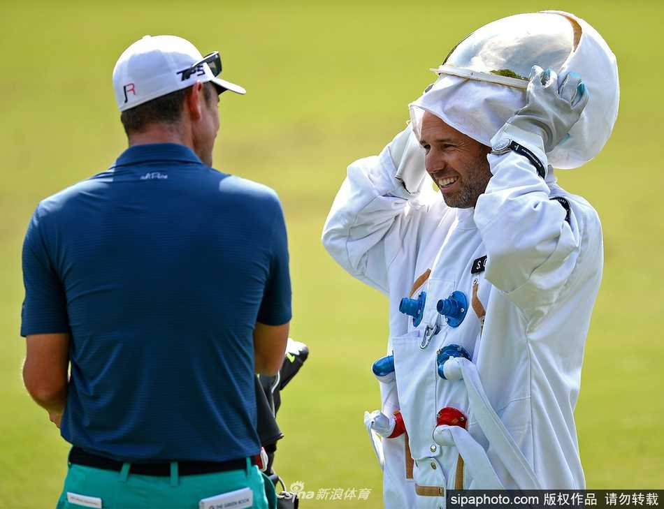 加西亚头戴宇航头盔，正在沙坑中全神贯注地准备击球，白色的宇航服与金黄色的沙坑形成鲜明对比，画面充满超现实趣味。