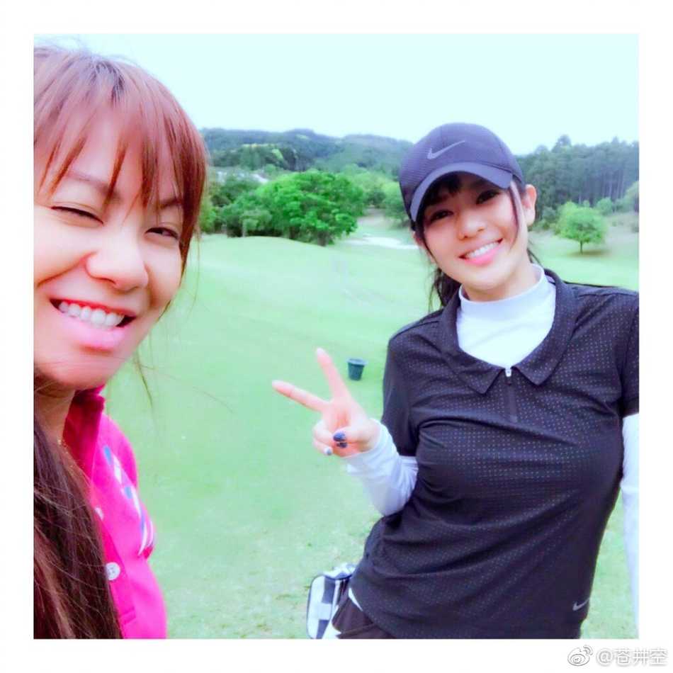 手持推杆，在果岭上露出俏皮可爱的表情，展现运动之余的轻松与欢愉