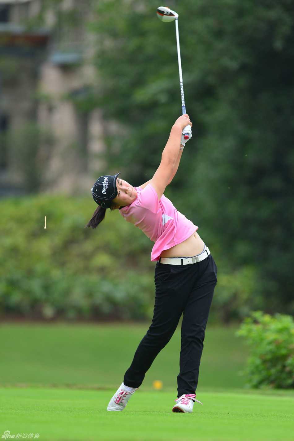 绿茵挥杆竞风采 高尔夫球赛展英姿 女选手在果岭边细致观察地形与草纹,为接下来的切杆或推杆做出冷静判断