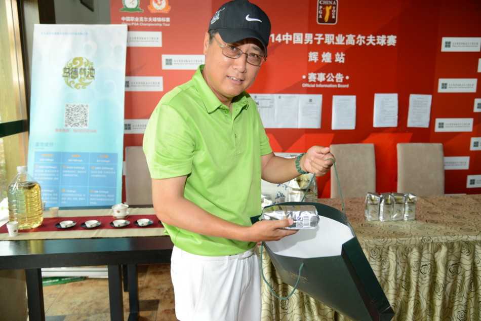 绿茵挥杆风尚尽显 天然苏打水润泽高球雅集 嘉宾与身着统一服装的球童在球道中央微笑合影,背景是起伏的沙坑与远山,展现和谐的合作关系。