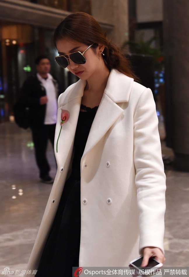 陈露在酒店走廊停下脚步，面对镜头露出温婉而自信的微笑，简单的白色上衣衬托出她清雅的气质，宛如一道靓丽的风景线。