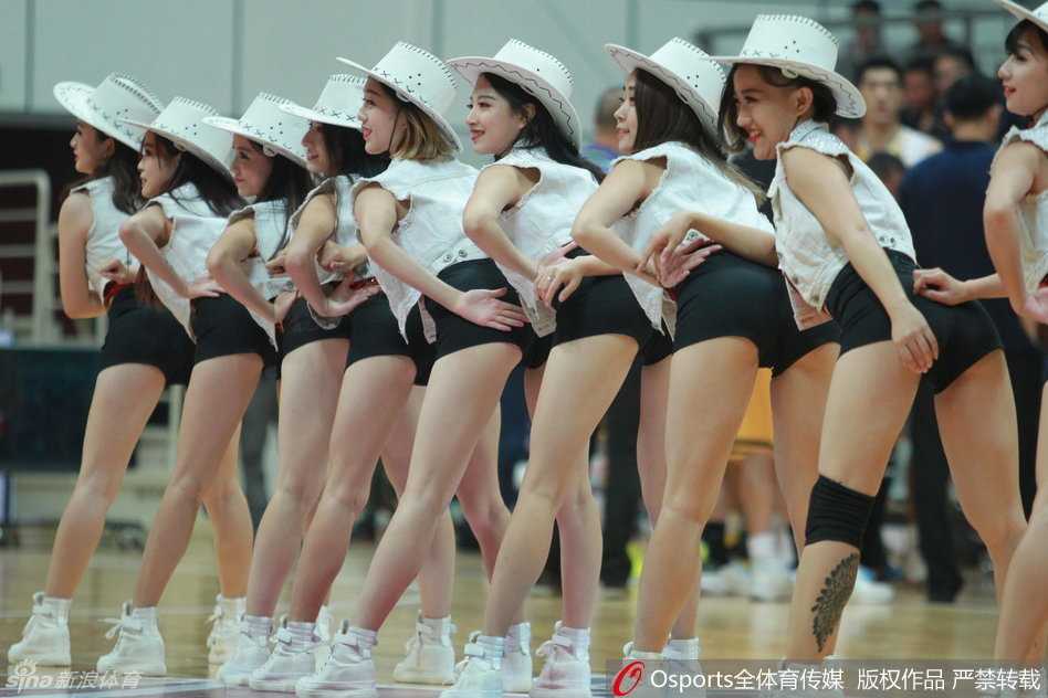 啦啦队摆出充满力量的ending pose，华丽的服装在灯光下熠熠生辉，尽显专业舞者的力与美